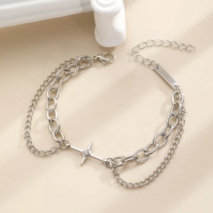 Detail of silver double-layer chain bracelet featuring a cross star charm and lobster clasp