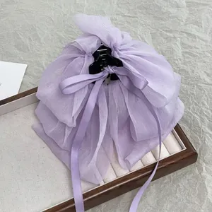 Macro shot of large purple chiffon bow hair claw clip with delicate layered fabric details
