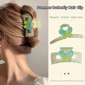 Detail of light green butterfly hair claw with blue and yellow gradient resin wings