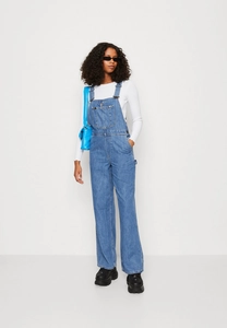 Detailed view of dark blue denim overalls featuring classic multi-pockets and wide-leg cut