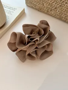 Détail d'un chouchou en satin aux tons terre avec un design floral en relief 3D élégant