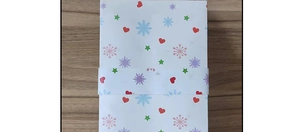 Detailed top view of white Christmas ornament box with red hearts and green stars