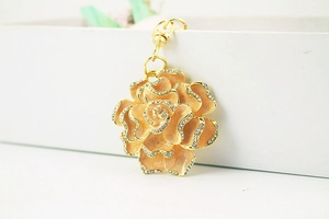 Detailed macro view of golden rose keychain with sparkling rhinestones and lobster clasp