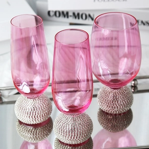 Élégants verres à vin roses avec base sphérique en strass argentés brillants sur un miroir