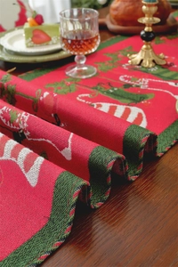 Detailed texture of Christmas table runner featuring festive Grinch legs and candy canes