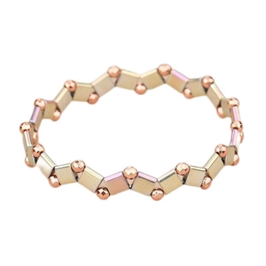 Macro shot of rose gold faceted beads and iridescent Tila blocks on a beaded bracelet