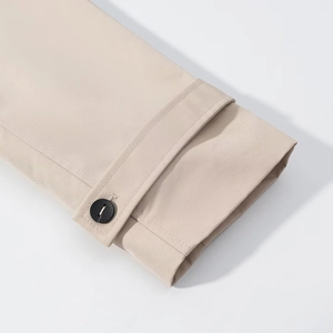 Short beige trench coat with notched lapel and cuff strap detail in twill fabric