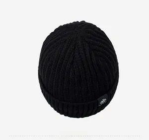 Vue de dessus d'un bonnet d'hiver noir en maille côtelée avec écusson flocon de neige