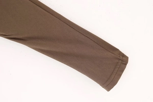 Detailed macro view showing the brown textured knit fabric and seam of the hooded top sleeve