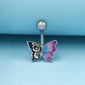 Détail macro du piercing nombril papillon avec crâne et ailes en dégradé de couleur
