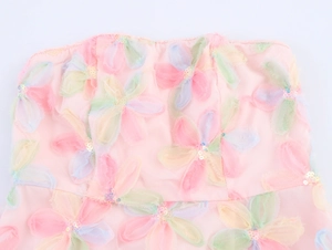 Détail de robe en tulle rose avec broderies de fleurs 3D et paillettes brillantes