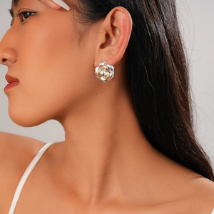Minimalist two-tone flower knot stud earrings in silver and gold on a model