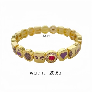 Vue détaillée du bracelet élastique luxueux plaqué or 18 carats avec breloques cœur et nœud