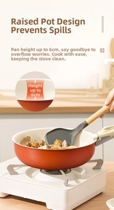 Detail showing 6cm deep non-stick orange frying pan with clams in a modern kitchen