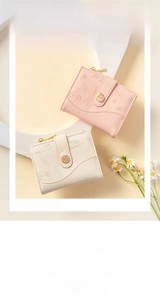 Close-up of pink and beige short wallets with delicate leaf embossing and metal charms