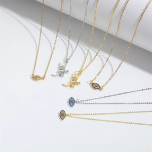 Gold and silver evil eye and cowboy boot pendant necklaces on white geometric stands