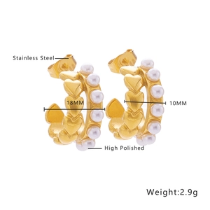 Detailed view of heart-shaped gold pearl earrings with polished stainless steel texture