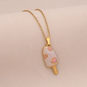 Detail of gold necklace featuring a white enamel ice cream pendant with pink hearts
