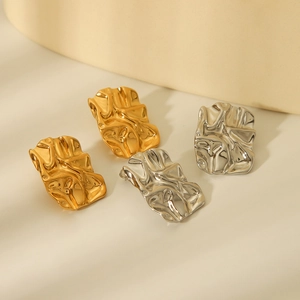 Detailed view of textured 18K gold and silver plated titanium steel lava fold earrings