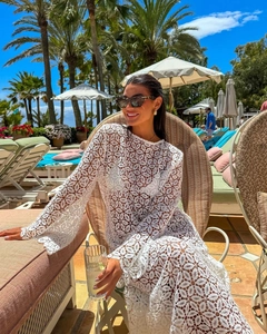 Close-up of white lace crochet long sleeve maxi dress details at poolside resort
