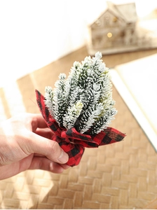 Close-up of a 13cm mini Christmas tree with snow-tipped needles and red plaid base