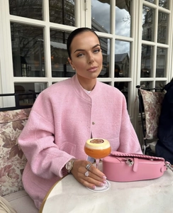 Close-up of pink wool coat texture with matching handbag in an elegant cafe setting