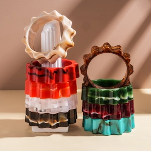 Esposizione di bracciali ondulati in acrilico effetto marmo su supporti in pietra