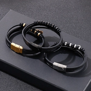 Close-up of woven leather bracelets with gold, silver, and black metal magnetic clasps