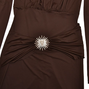 Détail de robe marron foncé montrant les plis à la taille et broche étoile argent