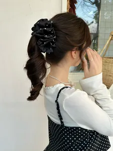 Polka dot satin scrunchie for women shown in a ponytail hairstyle with elegant styling