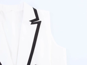 Gros plan du revers de gilet blanc avec garniture noire contrastée et couture soignée