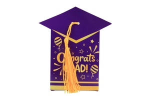 Detail of purple graduation cap gift box with yellow tassel and gold Congrats Grad text