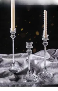 Detailed view of elegant glass candle holders with diamond cut texture and filler gems
