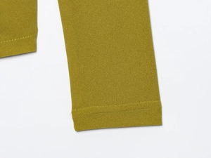 Dettaglio ravvicinato del top elasticizzato verde oliva con cuciture e trama del tessuto