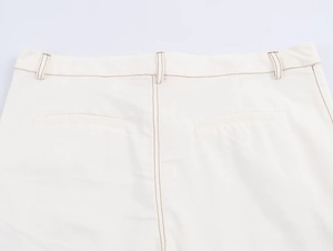 Detail view of high-waist trousers with contrast brown stitching and dual back pockets