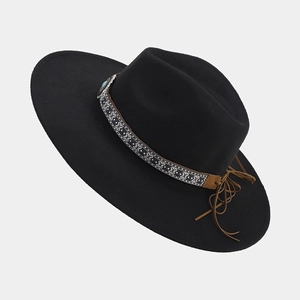 Detail of western fedora hat featuring turquoise stone and bohemian tassel trim