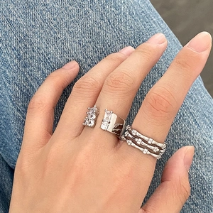 Detailed close-up of a triple-layered silver ring with pavé zircon stones on denim fabric