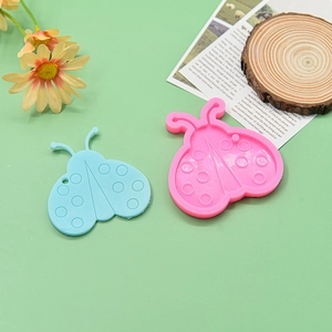 Detail of ladybug shaped silicone earring molds in blue and pink with hanging holes