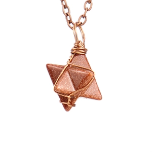 Detailed view of hand-woven wire wrapped hexagonal star pendant with natural stone