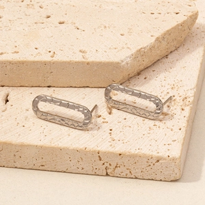 Dettaglio orecchini ovali martellati color argento su pietre naturali beige