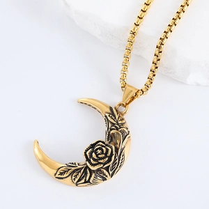 Macro view of golden crescent moon pendant with rose and leaf relief details