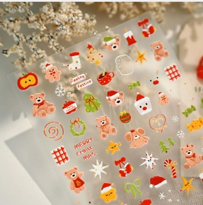 Detailed view of Christmas nail art stickers with bears, trees and festive holiday motifs