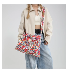 Dettaglio ravvicinato della borsa tote in tela a fiori colorati indossata a spalla