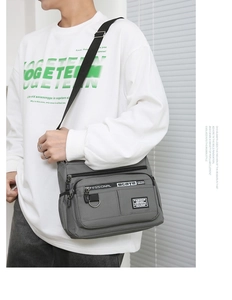 Side view of multi-pocket grey crossbody bag for men showing storage and adjustable strap