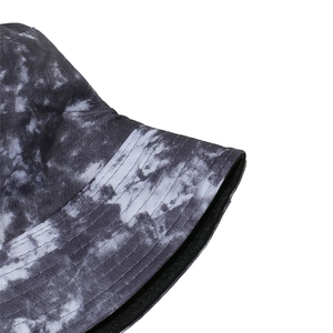 Detailed macro view of tie-dye bucket hat featuring grey marble pattern and reinforced stitching