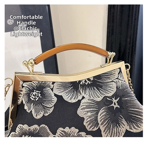 Detail of vintage floral jacquard bag with golden metal clasp and amber resin handle