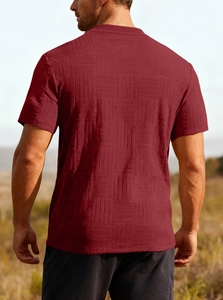 Close-up of deep red men's t-shirt showing 3D geometric knit texture and fabric detail