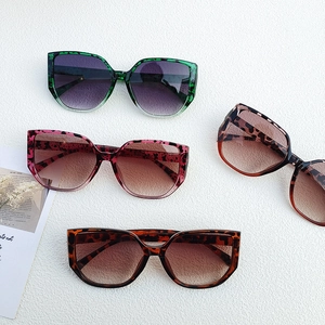Flat lay of oversized rimless sunglasses in leopard prints and amber with gradient lenses