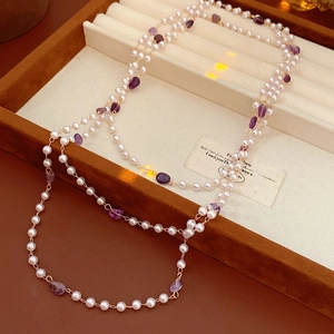 Macro view of vintage style pearl necklace with purple amethyst gems in a jewelry box