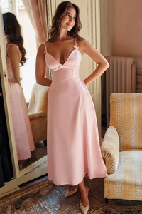 Detail of pink satin V-neck maxi dress featuring elegant bow decorations on shoulder straps